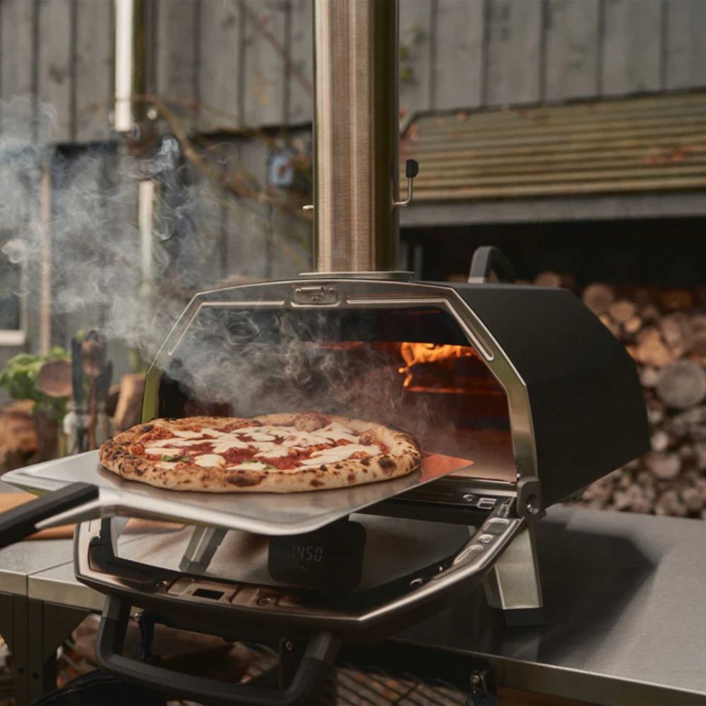 Ooni Karu 2 Pro - 16 inch multi-fuel outdoor pizza oven - cooked pizza being removed from oven