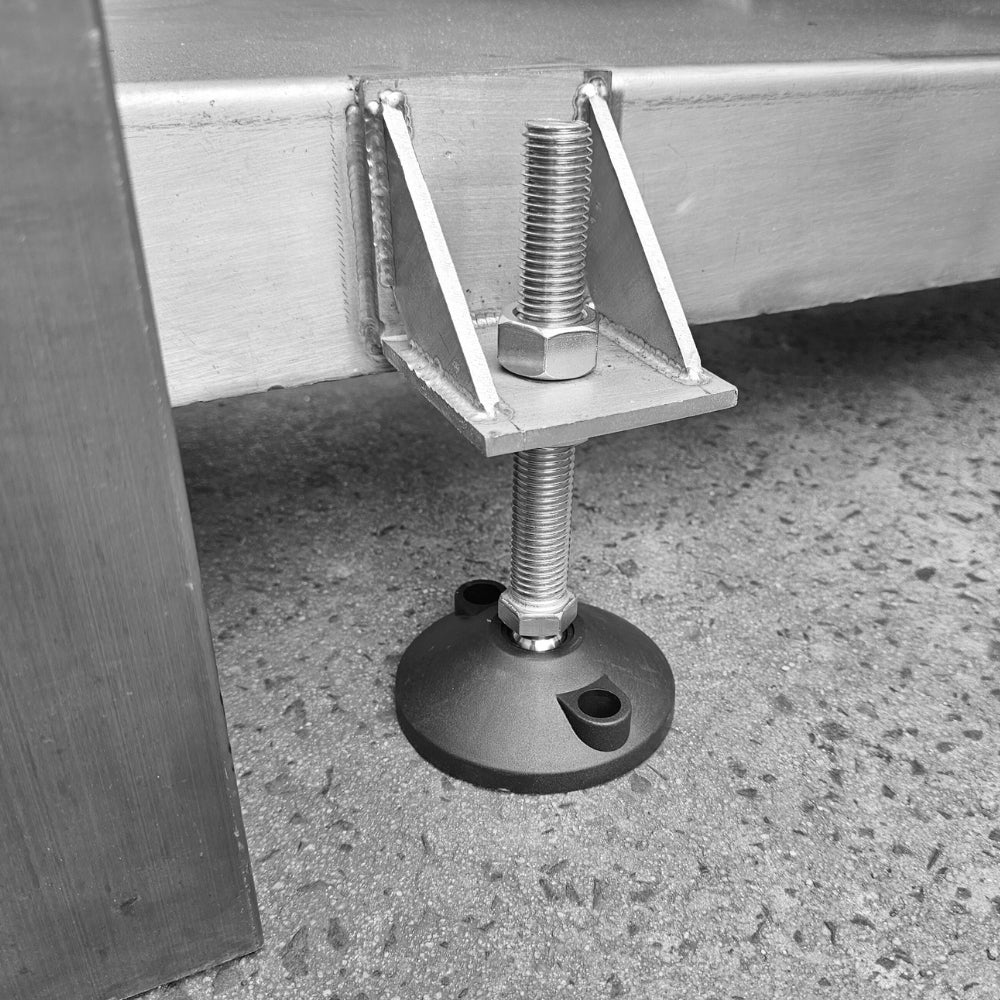 Adjustable metal foot with screw mechanism on a concrete floor