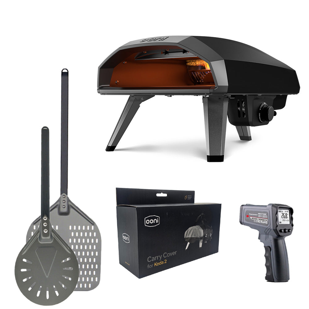 Ooni Koda 2 14" Pizza Oven with accessories including pizza peel, spinner peel, infrared thermometer and waterproof carry cover.