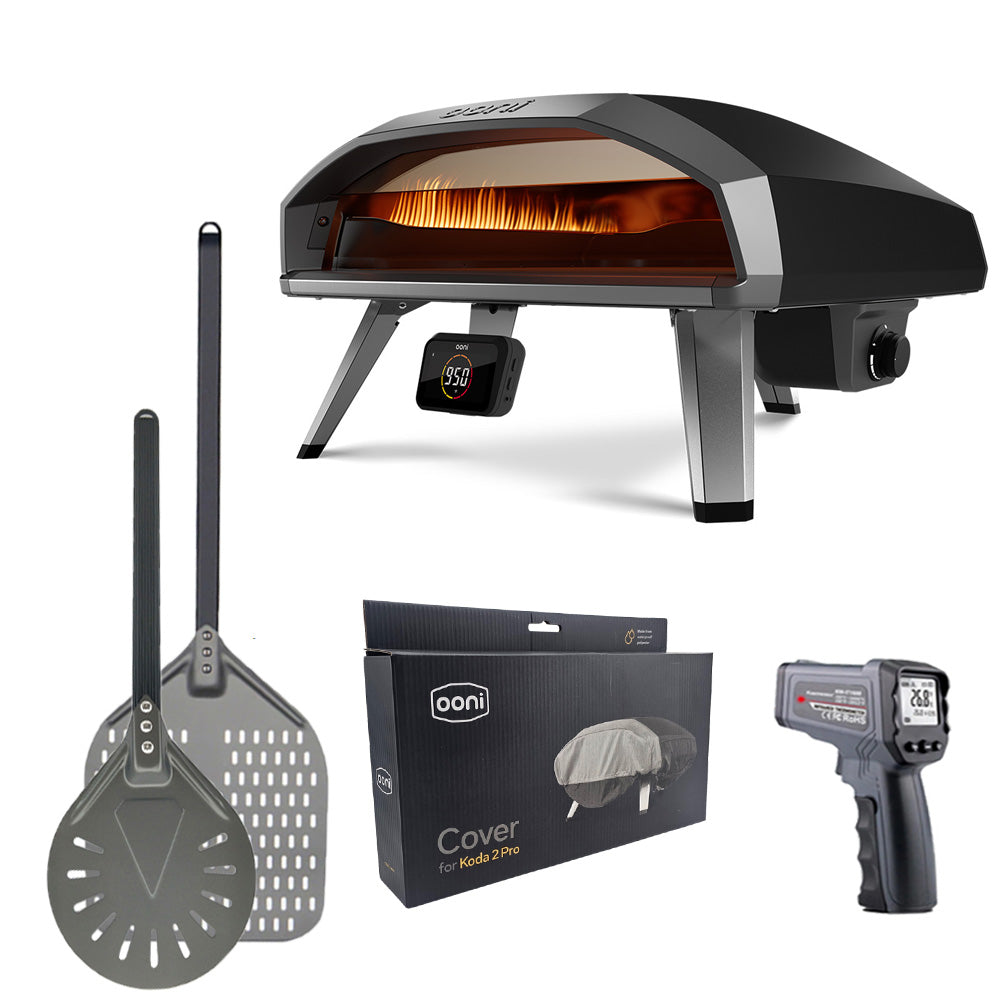 Ooni Koda 2 Pro 18" Pizza Oven with accessories including pizza peel, spinner peel, infrared thermometer and waterproof carry cover.