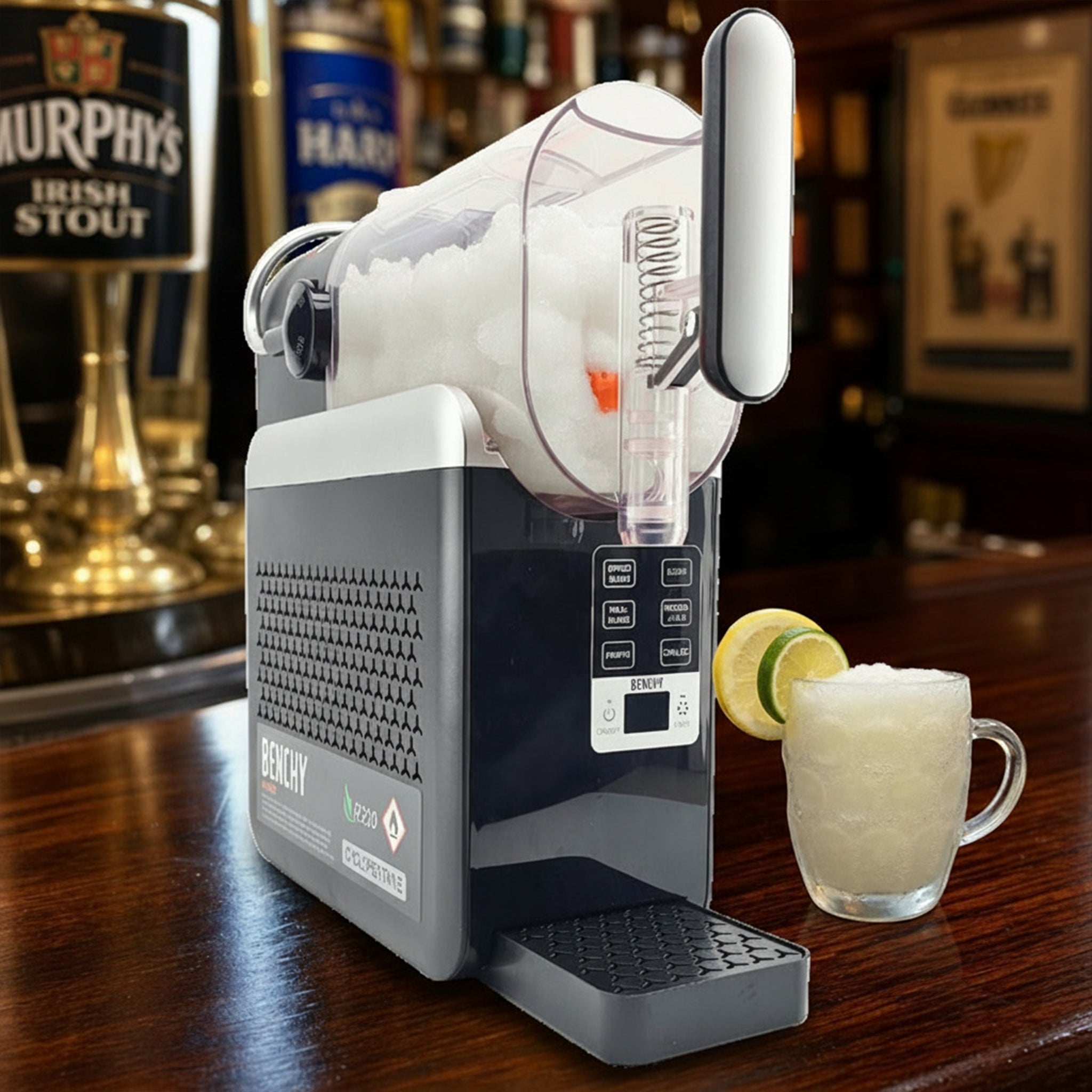 A countertop beverage maker shown on a wooden bar counter with a glass of slushy and beer taps blurred in the background, indicating a lifestyle setting.