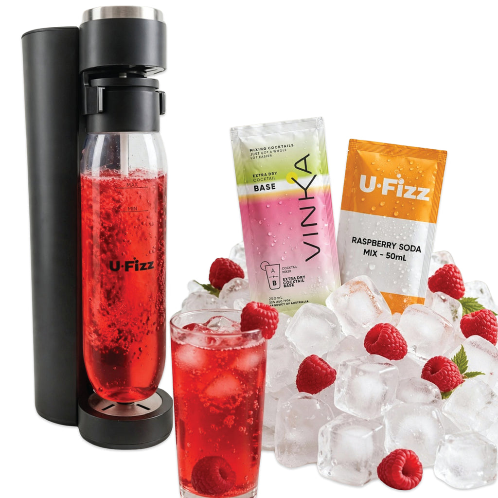 A U-Fizz carbonated water bottle filled with red drink stands on a white background, alongside a glass of the same red drink with ice and raspberries, plus two branded pouches: a pink Vinka base pouch and an orange U-Fizz raspberry soda mix pouch. Ice and raspberries are arranged around the products.