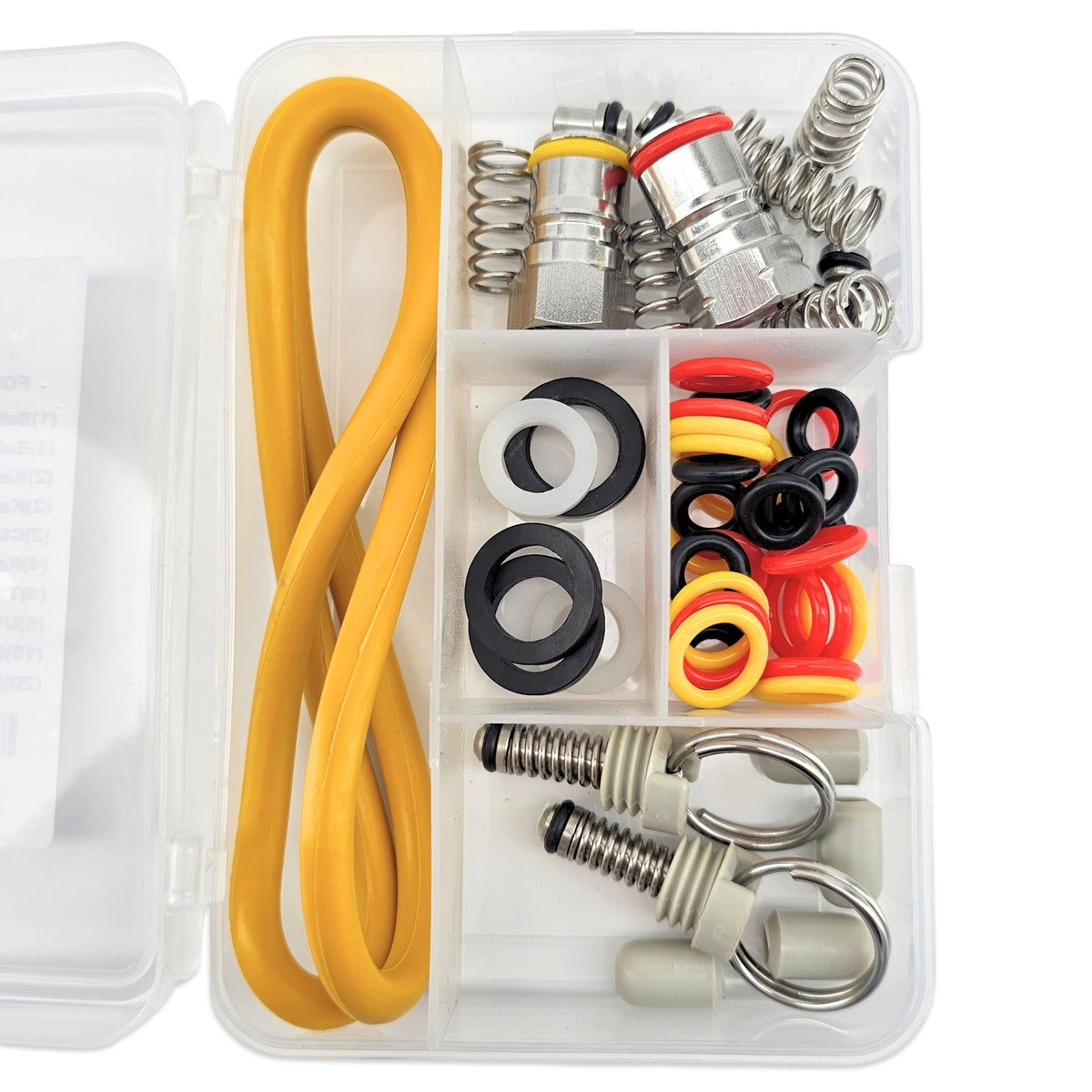 A clear plastic organizer box filled with hardware and gasket parts, including a long yellow hose, silver metal springs, black and red O-rings, white and black rings, and beige plastic clips, photographed on a white background.