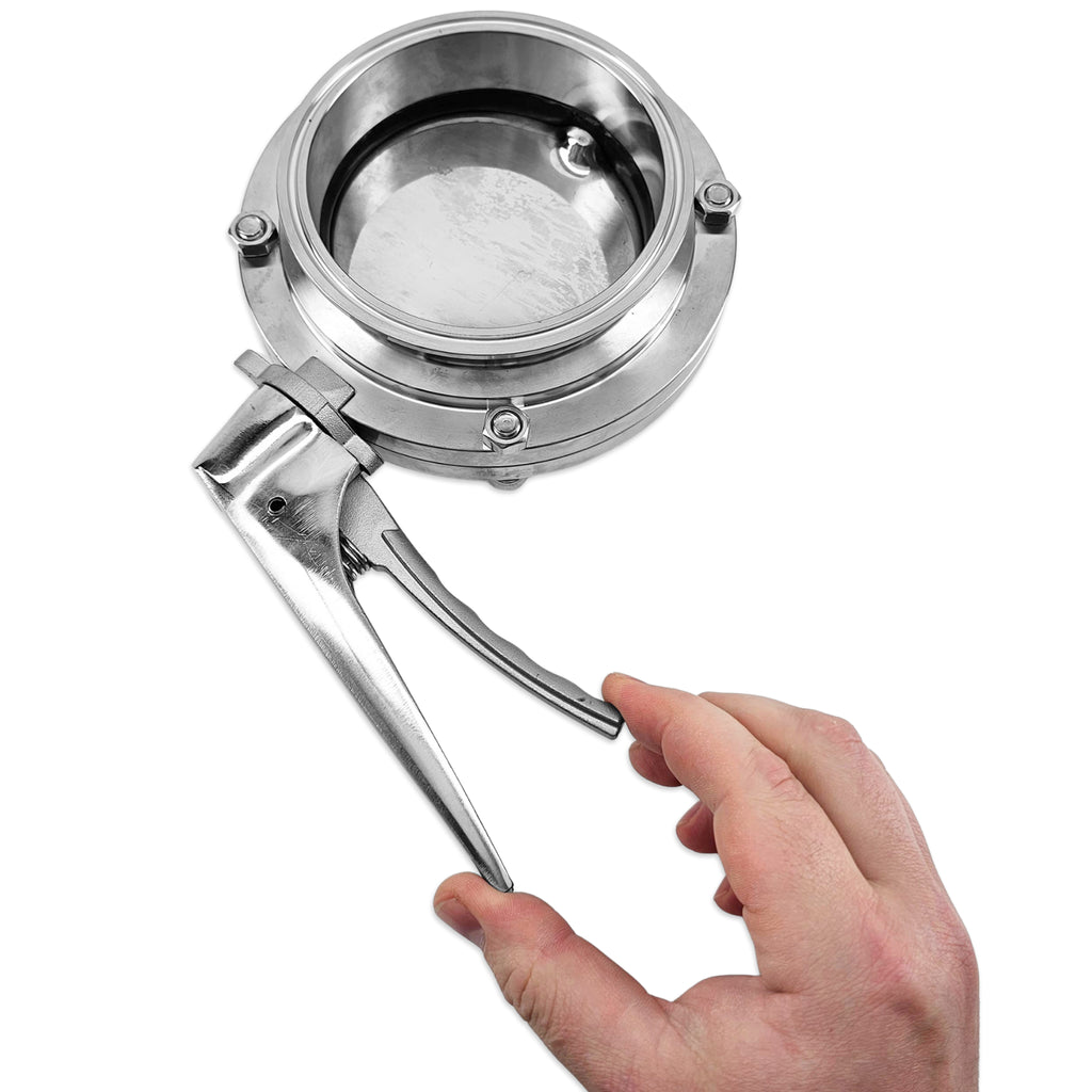 A stainless steel butterfly valve with a lever handle, shown with a human hand holding the handle to demonstrate scale and use, on a solid white background.